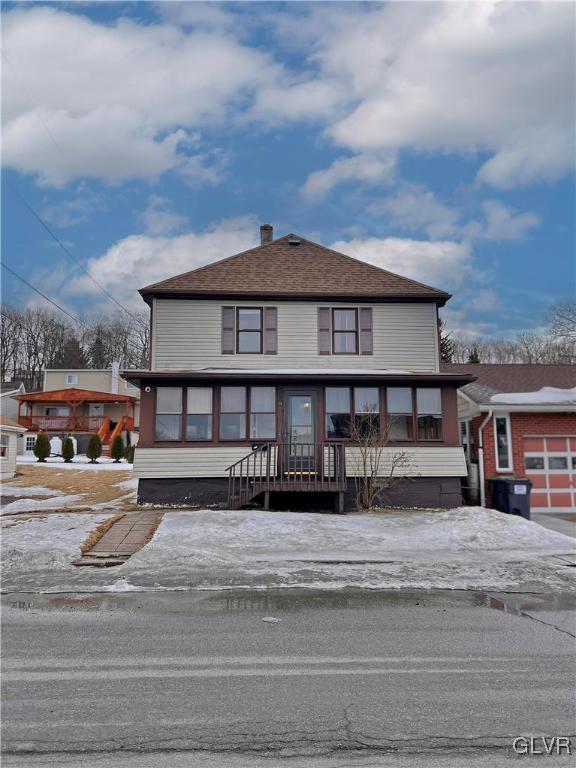 view of front of home featuring an attached garage and a chimney