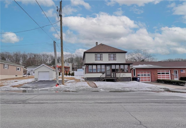 view of front of property with a detached garage, an outdoor structure, and aphalt driveway