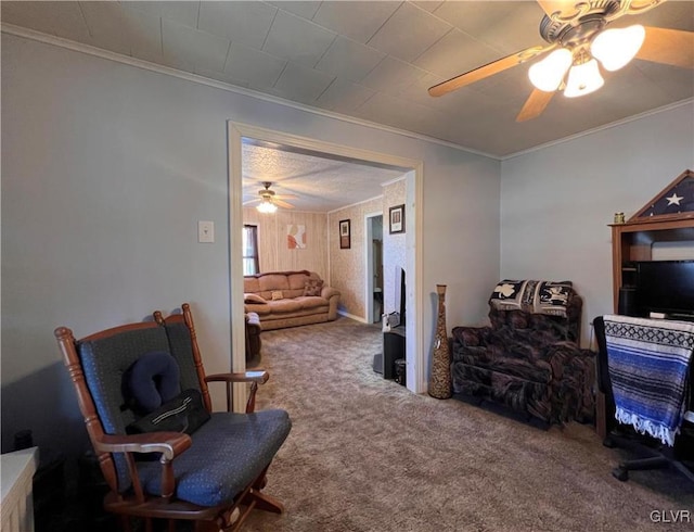 sitting room with crown molding, a ceiling fan, and carpet floors