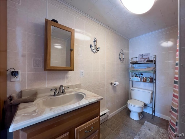 bathroom featuring tile walls, a baseboard heating unit, toilet, ornamental molding, and vanity