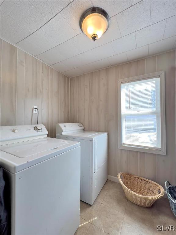 laundry area with laundry area, light tile patterned flooring, and washer and clothes dryer