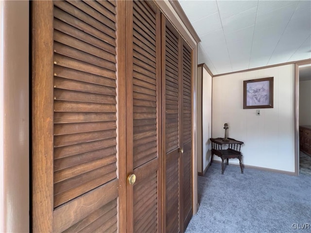 corridor featuring baseboards and carpet floors