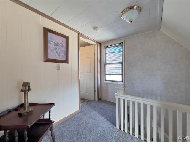 hallway featuring vaulted ceiling and carpet flooring