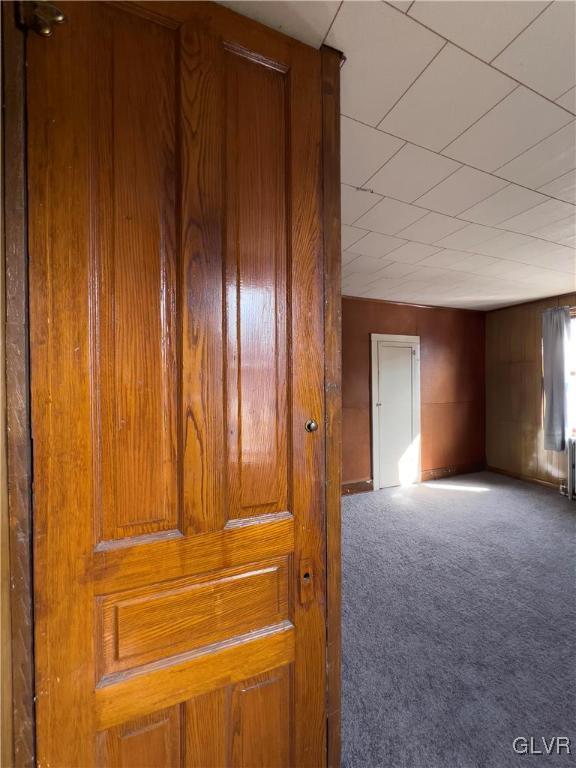 empty room featuring radiator heating unit and carpet floors