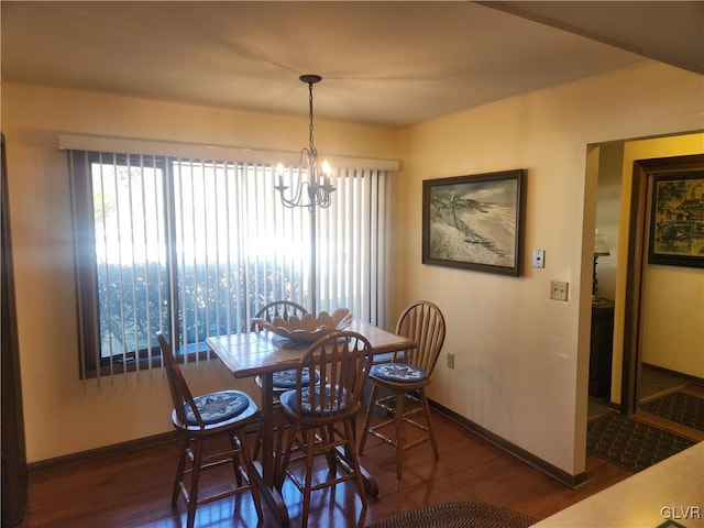 dining area featuring baseboards, an inviting chandelier, and wood finished floors