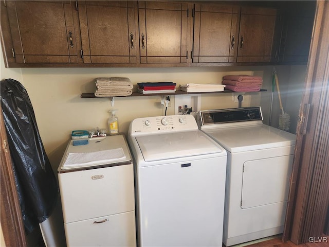 clothes washing area featuring cabinet space and separate washer and dryer