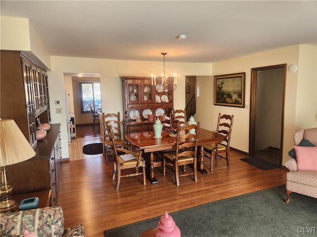 dining area with wood finished floors, baseboards, and a chandelier