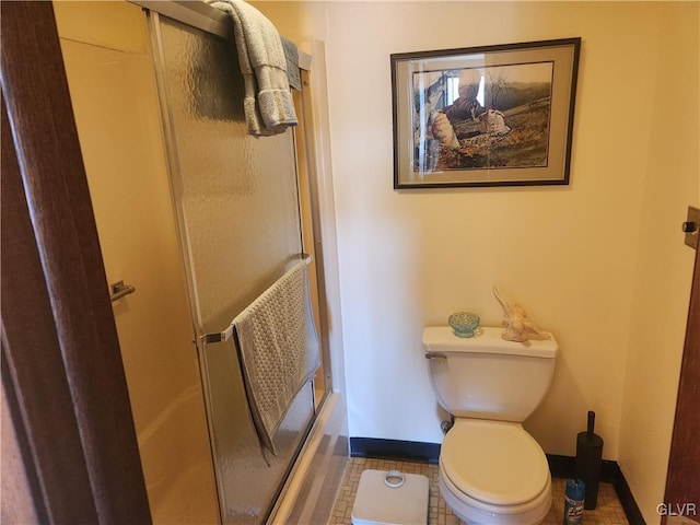 full bath with toilet, baseboards, and a shower with door