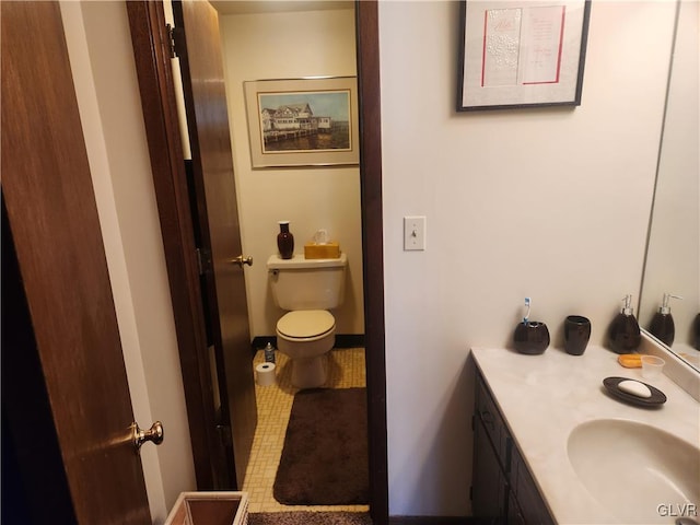 bathroom featuring vanity, toilet, and baseboards