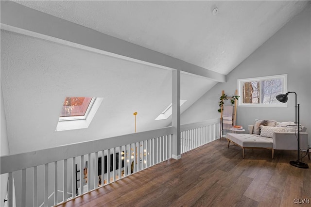 sitting room with lofted ceiling with skylight and wood finished floors