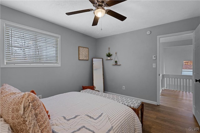 bedroom featuring wood finished floors, baseboards, and ceiling fan