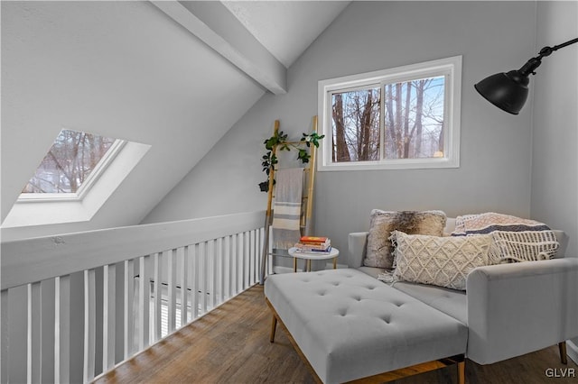 living area featuring vaulted ceiling with skylight and wood finished floors