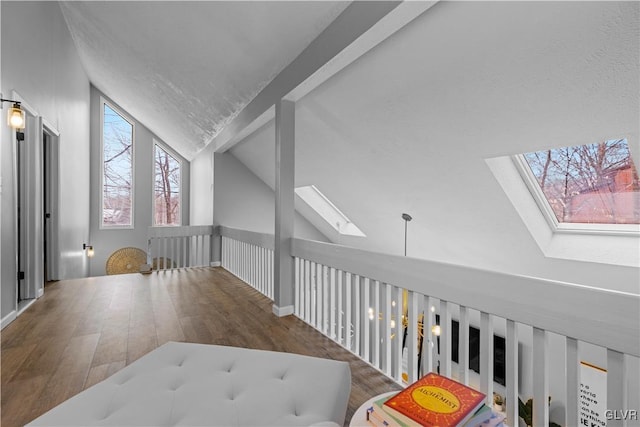 corridor featuring lofted ceiling with skylight and wood finished floors