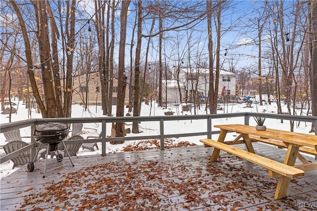 snow covered deck with a grill