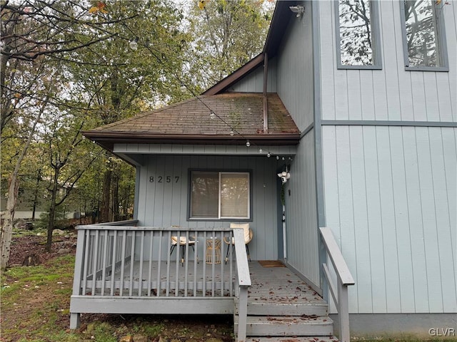 doorway to property with a shingled roof