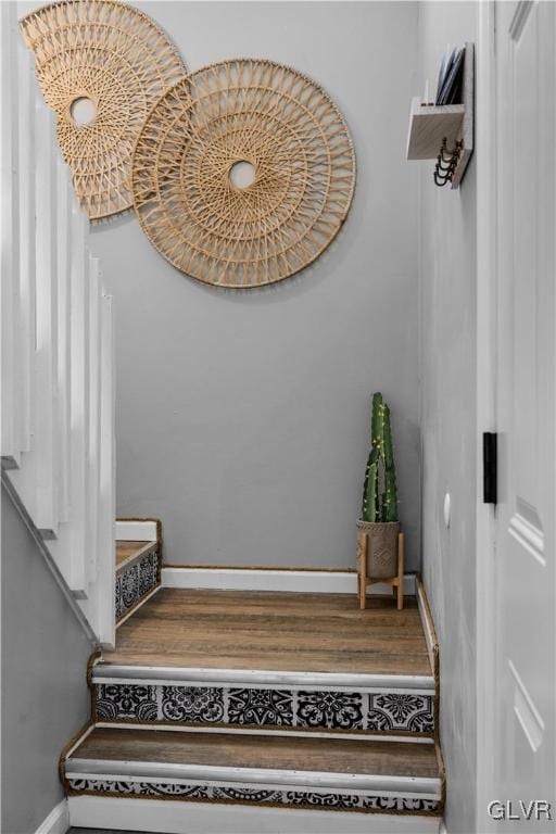 staircase featuring baseboards and wood finished floors