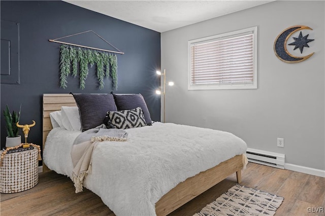 bedroom with hardwood / wood-style flooring, baseboards, and a baseboard radiator