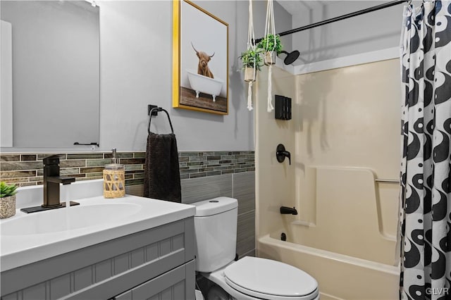 full bathroom featuring toilet, tile walls, wainscoting, shower / tub combo, and vanity