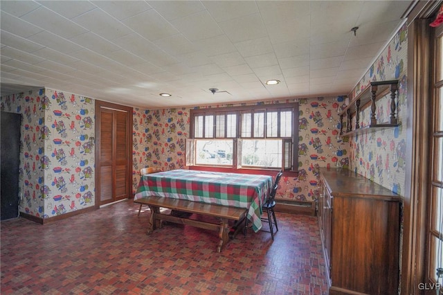 dining area with baseboards and wallpapered walls