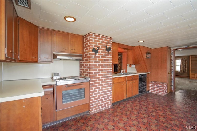 kitchen with gas range, wine cooler, brown cabinetry, and under cabinet range hood