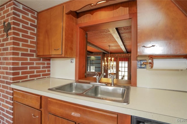 kitchen with dishwashing machine, a sink, light countertops, beamed ceiling, and brown cabinets