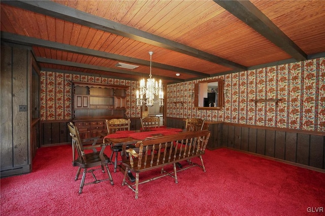 dining area with wallpapered walls, beam ceiling, carpet flooring, wainscoting, and an inviting chandelier