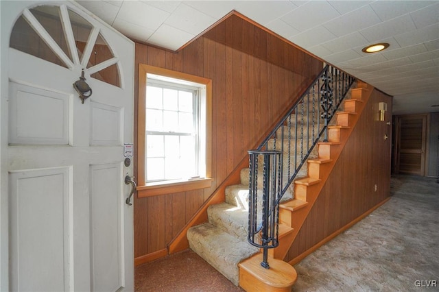 entrance foyer featuring wooden walls and stairs