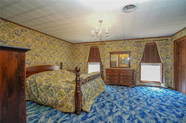 carpeted bedroom featuring wallpapered walls, an inviting chandelier, and visible vents