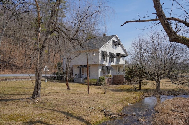 view of side of property featuring a lawn and a chimney