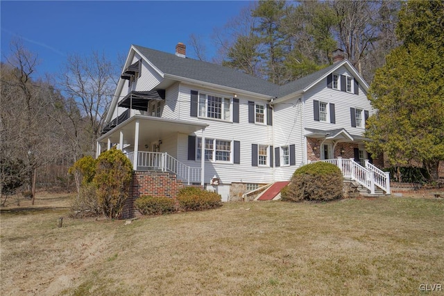 view of front of home with a front lawn, a balcony, and a chimney