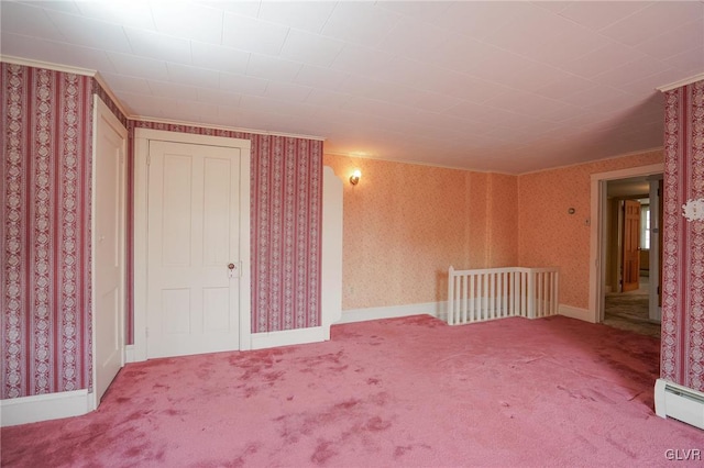 carpeted spare room with baseboard heating, wallpapered walls, and baseboards