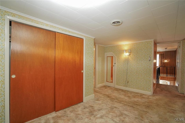 interior space featuring visible vents, wallpapered walls, crown molding, baseboards, and carpet floors