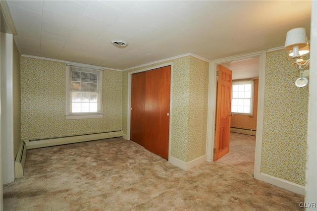 carpeted empty room with wallpapered walls, crown molding, visible vents, and a baseboard radiator