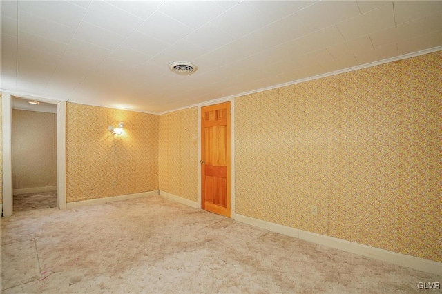 carpeted empty room featuring visible vents, wallpapered walls, and baseboards