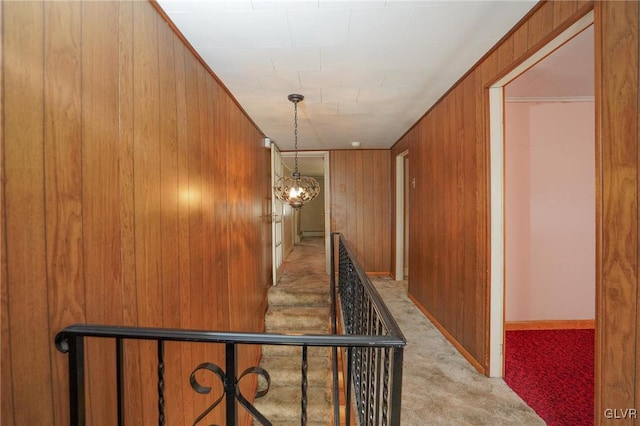 corridor featuring carpet floors and wooden walls