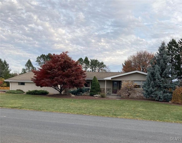 ranch-style home featuring a front lawn