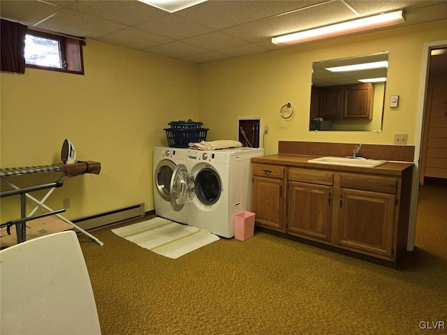 clothes washing area with baseboard heating, a sink, cabinet space, separate washer and dryer, and light colored carpet