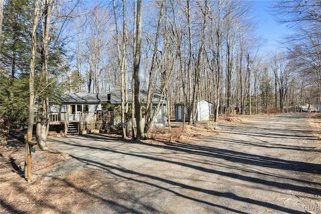 exterior space featuring aphalt driveway and a wooden deck