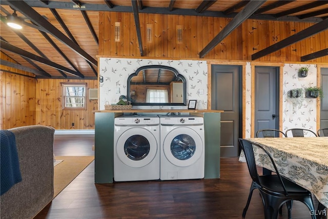 clothes washing area featuring wood finished floors, laundry area, wood walls, wooden ceiling, and washing machine and dryer