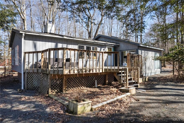 back of house with a deck and a chimney