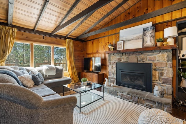 living area featuring a stone fireplace, lofted ceiling with beams, wooden walls, and wood ceiling