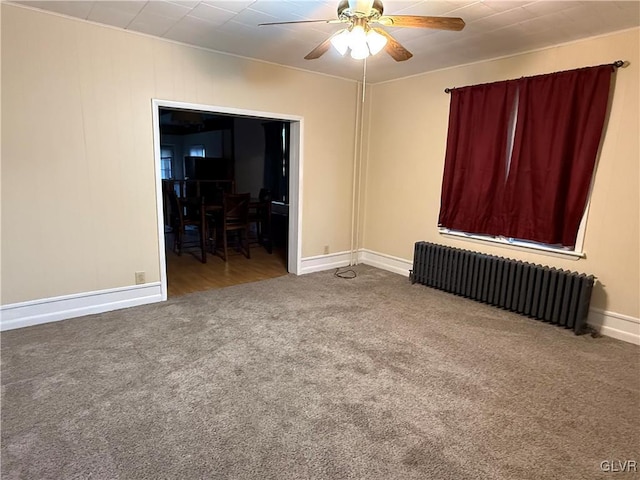 spare room with baseboards, carpet, ceiling fan, and radiator heating unit