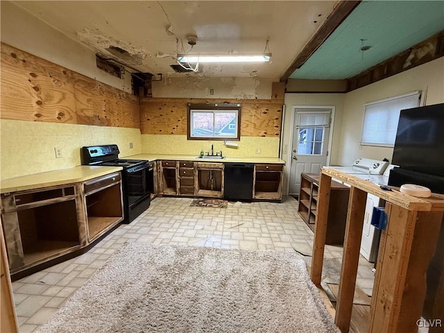 kitchen featuring decorative backsplash, black appliances, light countertops, and washing machine and clothes dryer