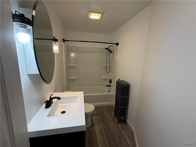 full bath featuring vanity, radiator, wood finished floors, shower / bathing tub combination, and toilet