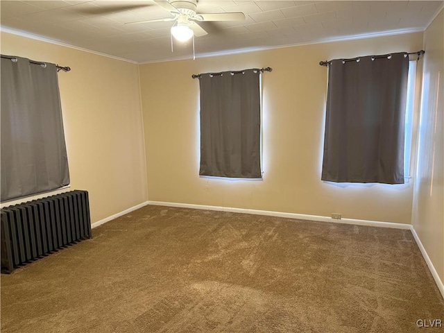 unfurnished room featuring radiator, baseboards, ornamental molding, carpet flooring, and a ceiling fan