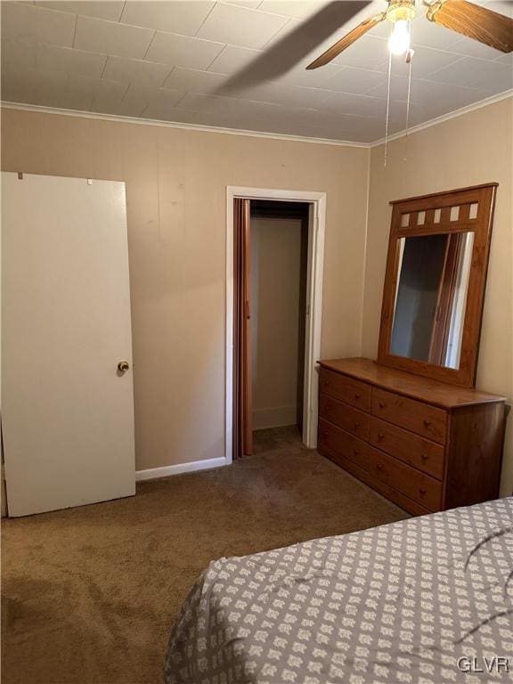 unfurnished bedroom with crown molding, baseboards, ceiling fan, carpet floors, and a closet