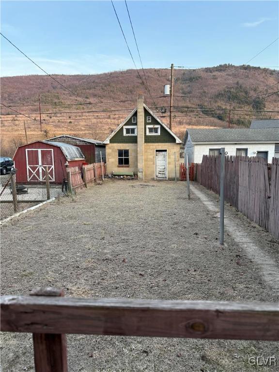 exterior space with a storage unit, an outbuilding, a barn, and fence