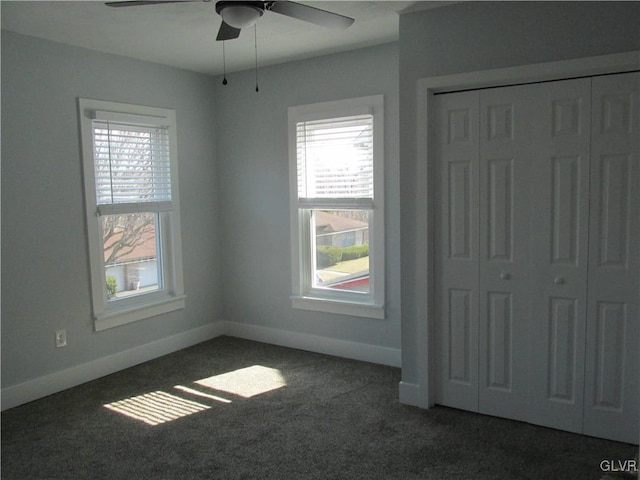 unfurnished bedroom featuring a closet, a ceiling fan, baseboards, and carpet floors