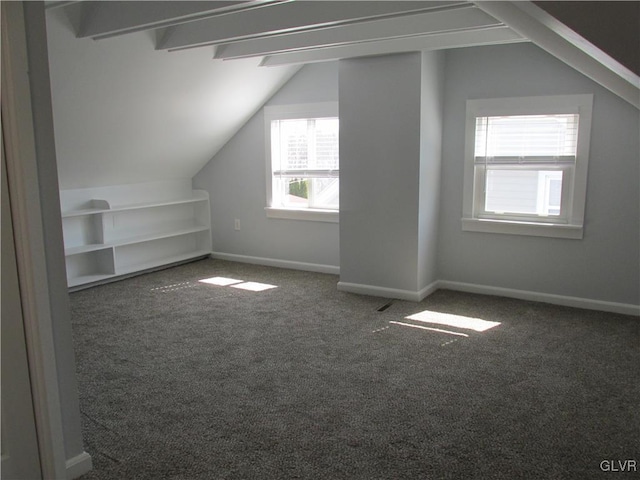 additional living space featuring baseboards, vaulted ceiling with beams, and carpet