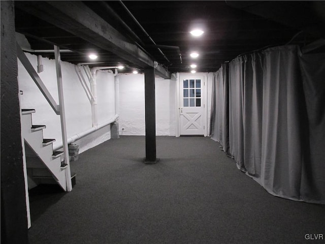 below grade area featuring stairway and carpet flooring